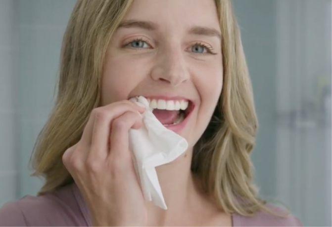 Nainen kuivaa hampaansa käsipaperilla