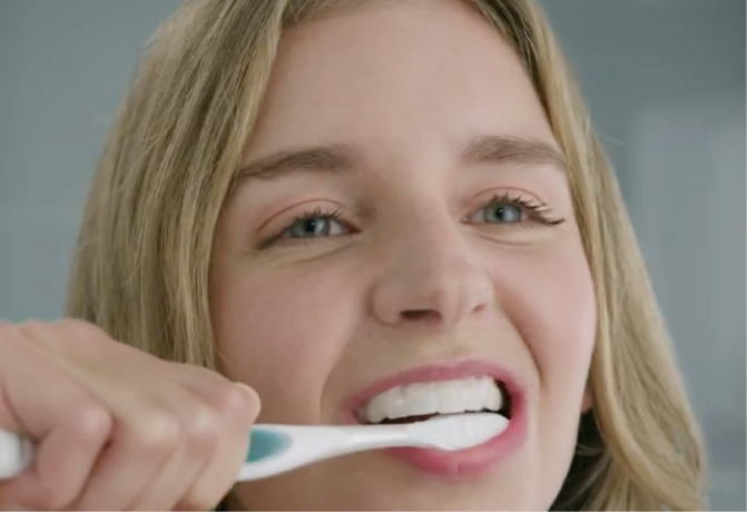 Nainen harjaa hampaansa